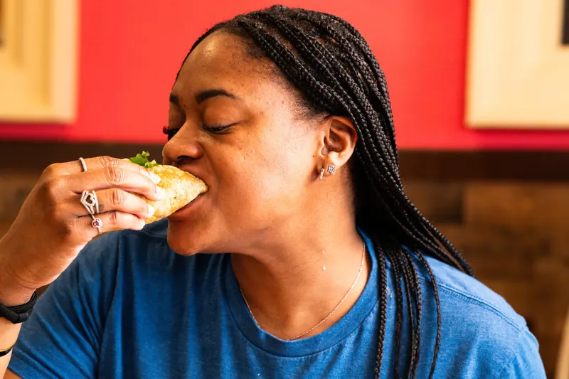 A guest biting into a taco at El Caporal