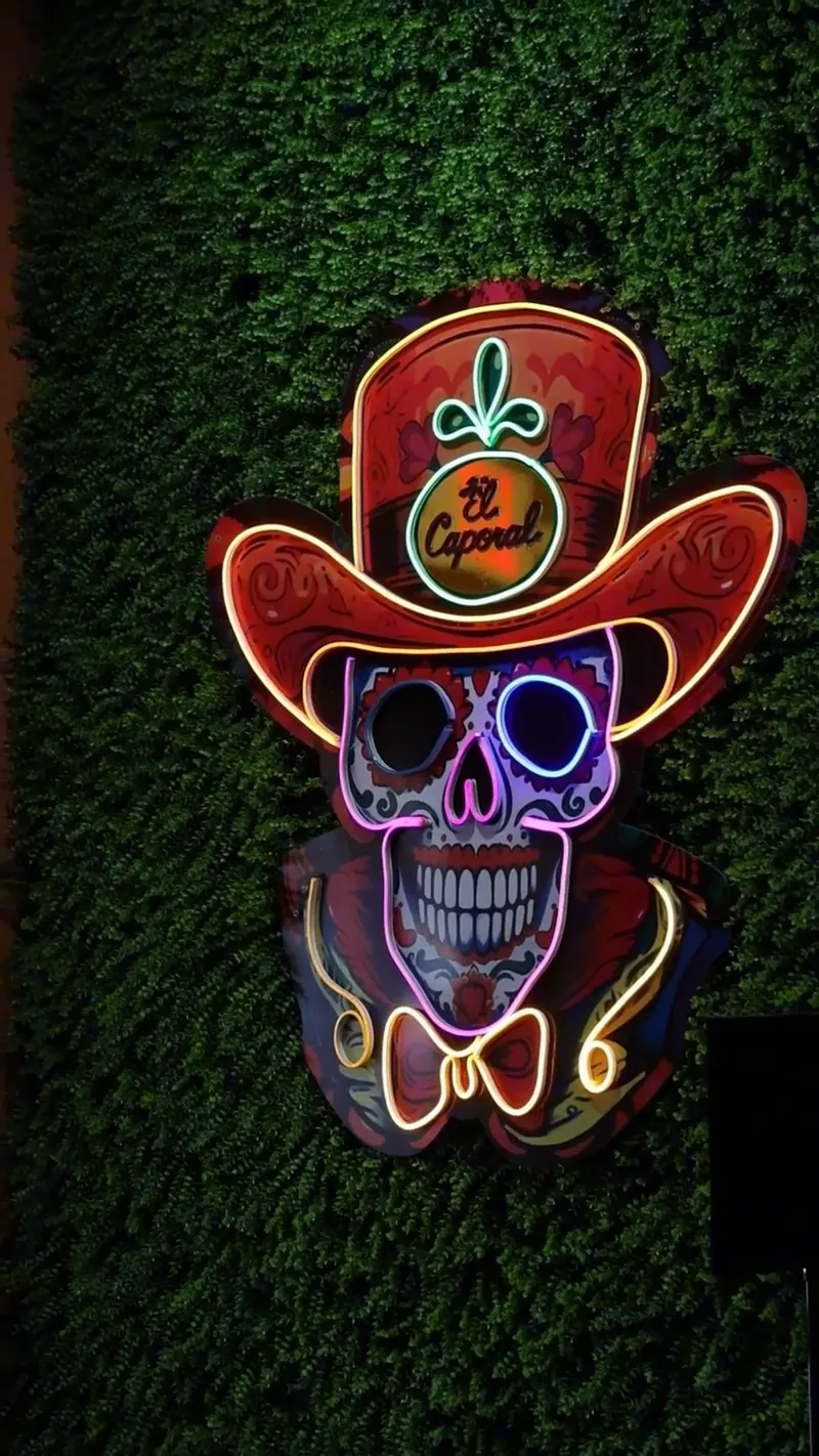 The neon calavera vaquero sign inside El Caporal